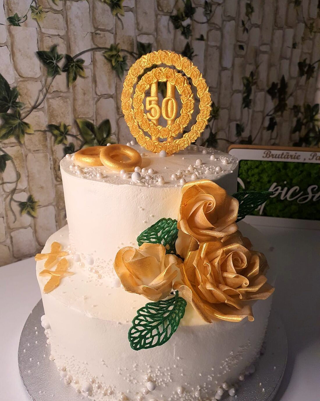 Tort aniversar alb cu trandafiri aurii și cifra 50